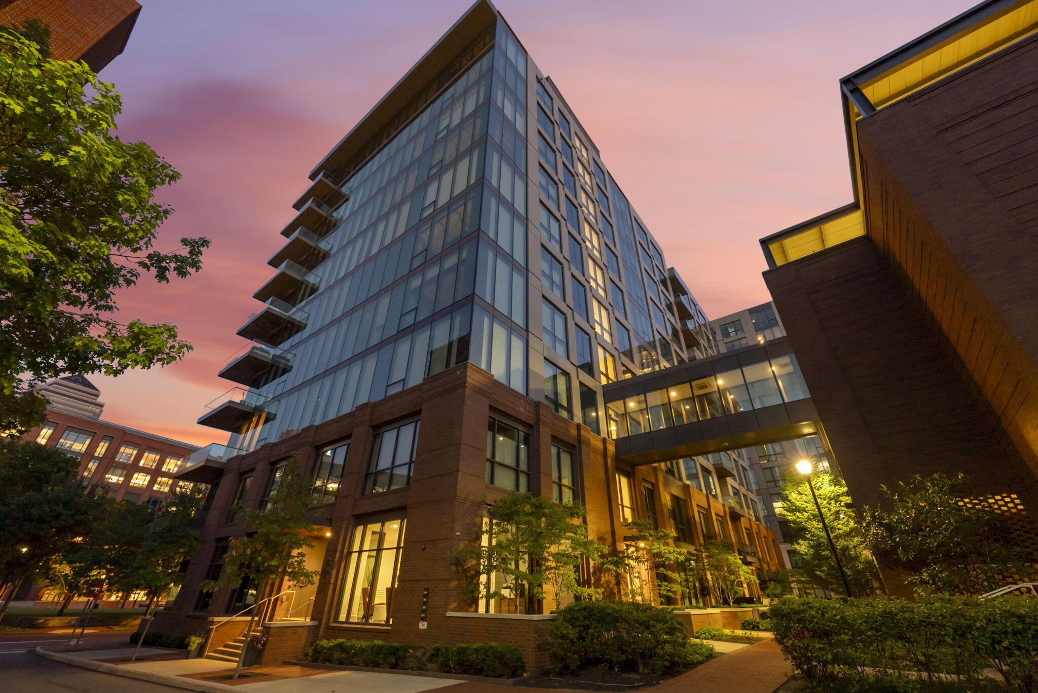 Glass and brick condominium high-rise on John H McConnell Boulevard at sunset